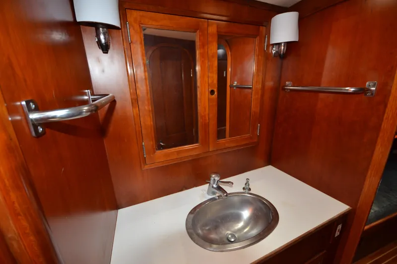 Slide: The Image of Hinckley Sou'wester 59 yacht bathroom with wooden cabinetry and stainless steel sink, 1992 model. - 44