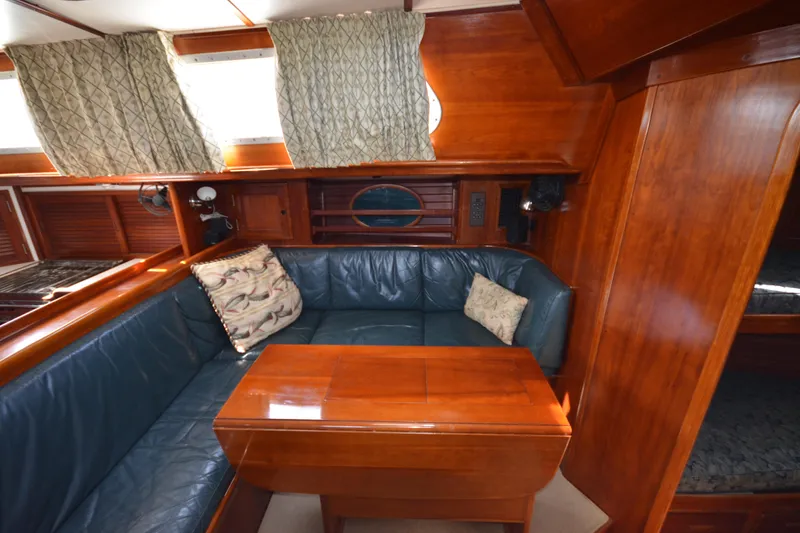 Slide: The Image of Luxurious wooden interior of a 1992 Hinckley Sou'wester 59 yacht with plush seating and cushions. - 48