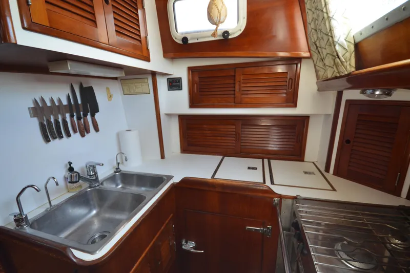 Slide: The Image of Galley kitchen in 1992 Hinckley Sou'wester 59 yacht with wooden cabinetry and stainless steel sink. - 51
