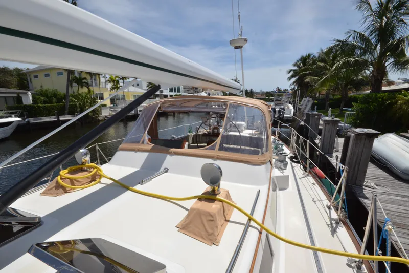 Slide: The Image of Hinckley Sou'wester 59 yacht docked, showcasing deck and cockpit, surrounded by palm trees. - 66