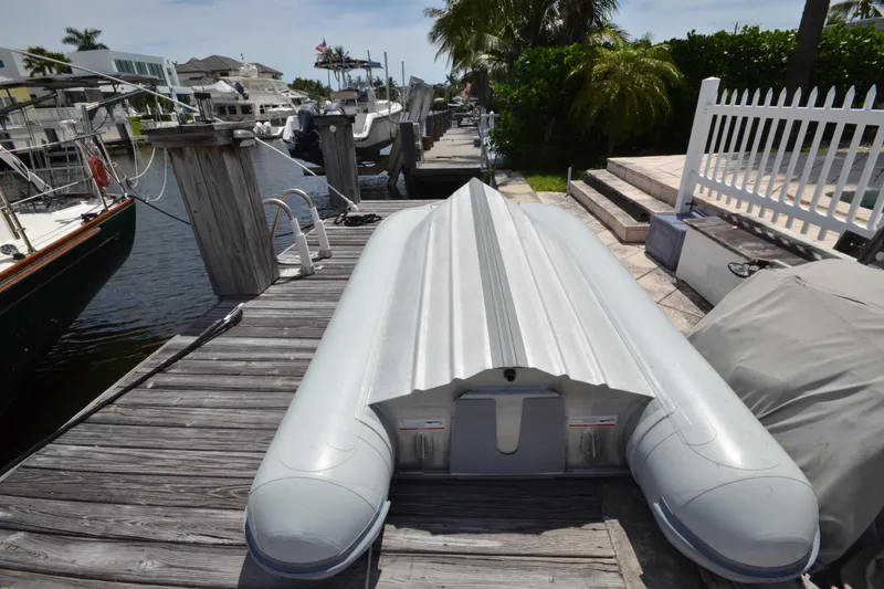 Slide: The Image of Docked inflatable boat beside Hinckley Sou'wester 59 yacht, 1992 model, in a sunny marina. - 69