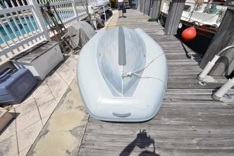 Slide: The Image of Inflatable dinghy on dock beside Hinckley Sou'wester 59 yacht, 1992 model. - 70