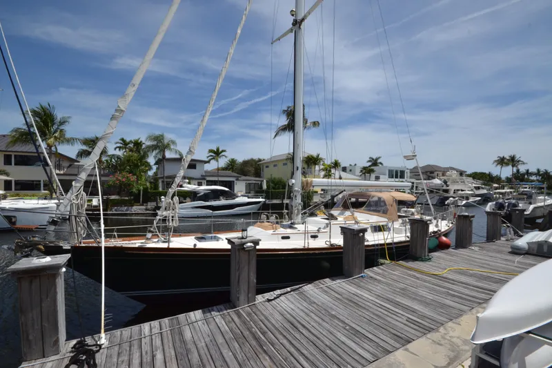 Slide: The Image of Hinckley Sou'wester 59 sailboat docked at a marina, surrounded by palm trees, 1992 model. - 71
