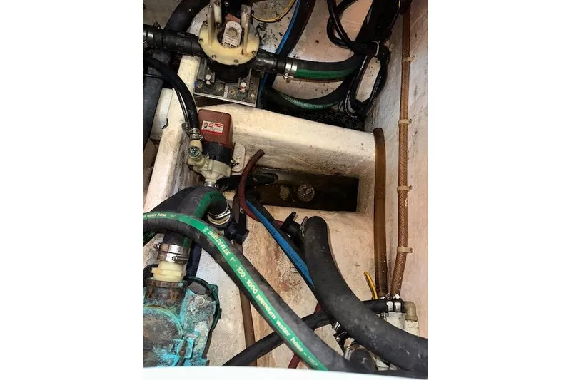 Slide: The Image of Engine compartment of a 1992 Hinckley Sou'wester 59 sailboat, showing hoses and mechanical components. - 73