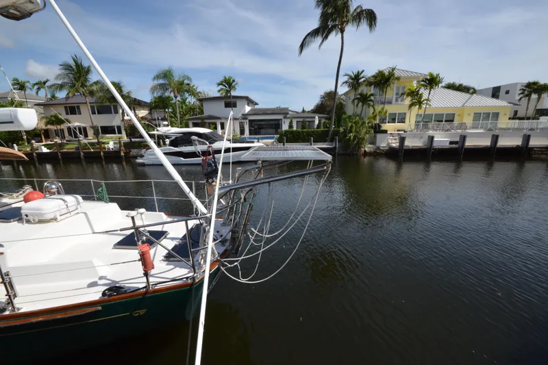 Slide: The Image of Hinckley Sou'wester 59 yacht docked by waterfront homes, surrounded by palm trees, 1992 model. - 9