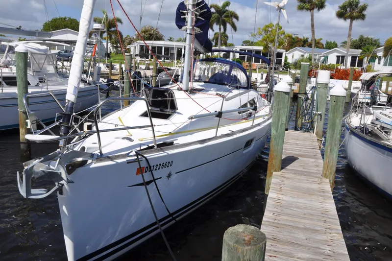 Slide: The Image of 2010 Jeanneau Sun Odyssey 36i sailboat docked at marina, surrounded by other boats. - 2