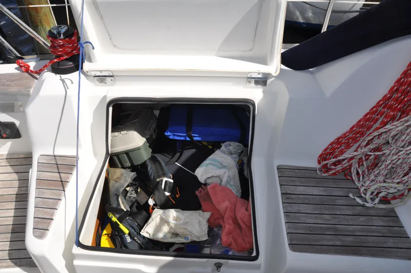Slide: The Image of Open storage compartment on 2010 Jeanneau Sun Odyssey 36i sailboat, containing various boating gear. - 23