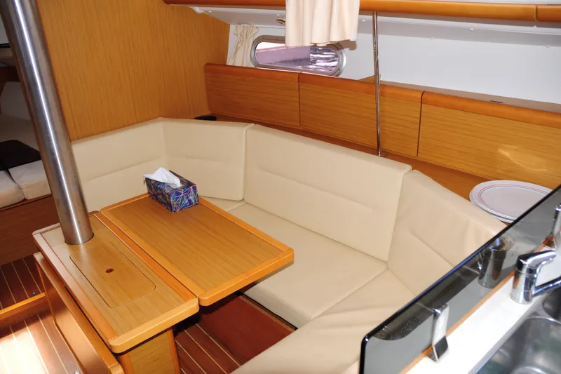 Slide: The Image of Interior of 2010 Jeanneau Sun Odyssey 36i yacht with cozy seating and wooden table. - 28