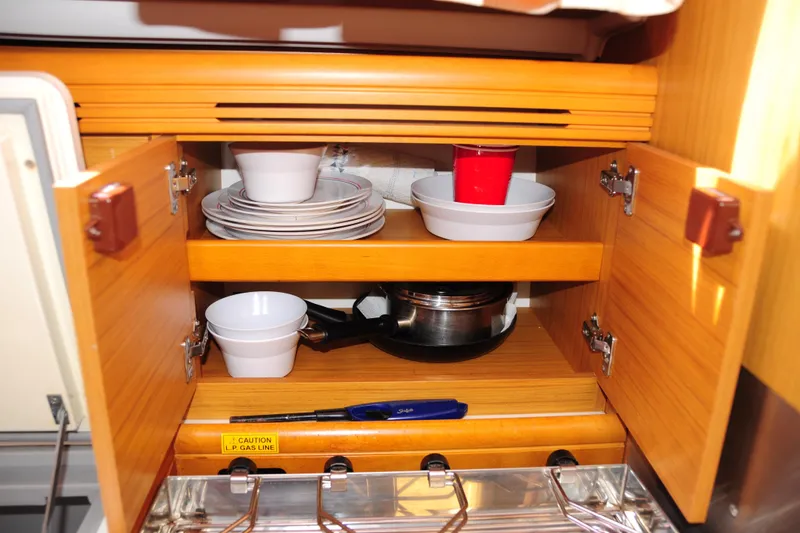 Slide: The Image of Cabinet interior of 2010 Jeanneau Sun Odyssey 36i yacht with dishes and cookware. - 34