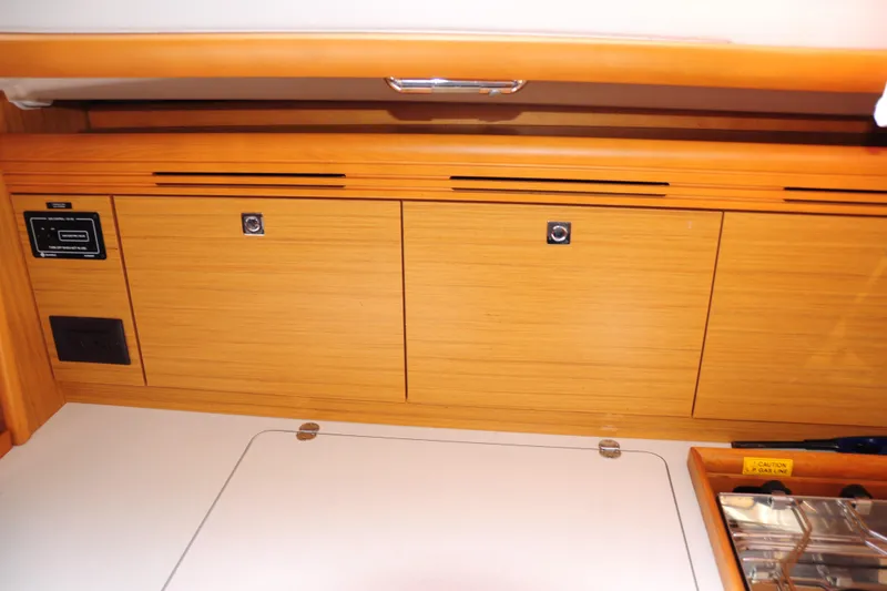Slide: The Image of Interior cabinetry of 2010 Jeanneau Sun Odyssey 36i sailboat, featuring wooden storage compartments. - 36