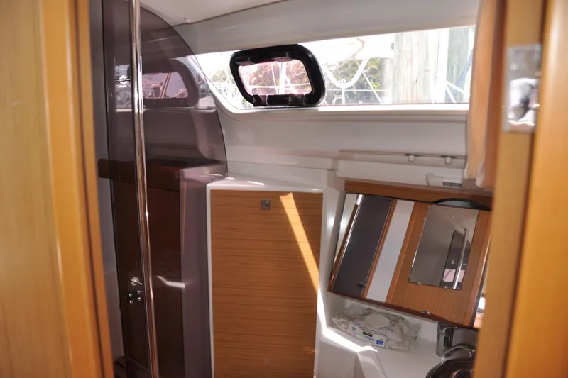 Slide: The Image of Interior of 2010 Jeanneau Sun Odyssey 36i sailboat, featuring wooden cabinetry and a compact bathroom. - 45