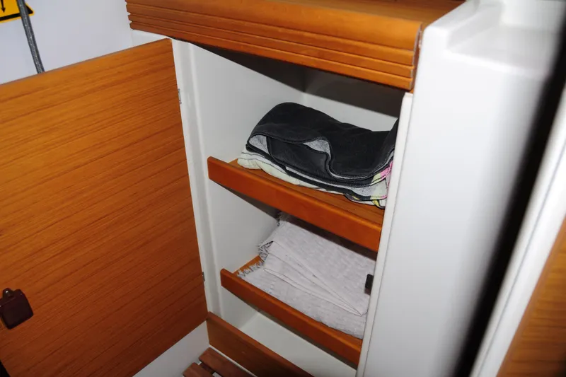 Slide: The Image of Cabinet interior on 2010 Jeanneau Sun Odyssey 36i yacht with folded clothes. - 51