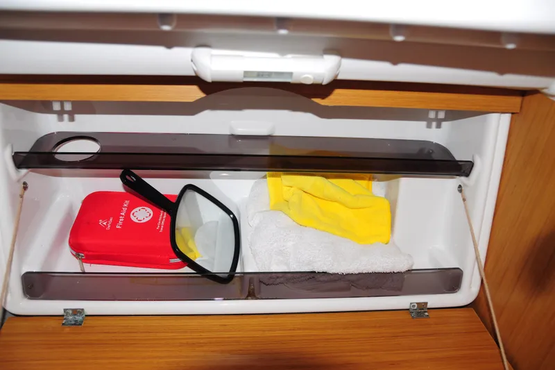 Slide: The Image of Storage compartment in Jeanneau Sun Odyssey 36i yacht with first aid kit and towels. - 53
