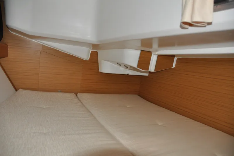 Slide: The Image of Interior cabin of 2010 Jeanneau Sun Odyssey 36i sailboat, featuring cozy bedding and wooden paneling. - 58