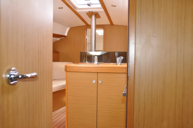 Slide: The Image of Interior view of 2010 Jeanneau Sun Odyssey 36i sailboat, featuring wooden cabinetry and seating. - 64
