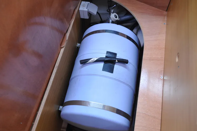 Slide: The Image of Storage compartment in a 2010 Jeanneau Sun Odyssey 36i sailboat, featuring a secured cylindrical tank. - 70