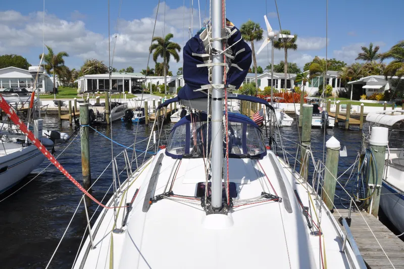 Slide: The Image of Jeanneau Sun Odyssey 36i sailboat docked at marina, surrounded by palm trees and waterfront homes. - 8