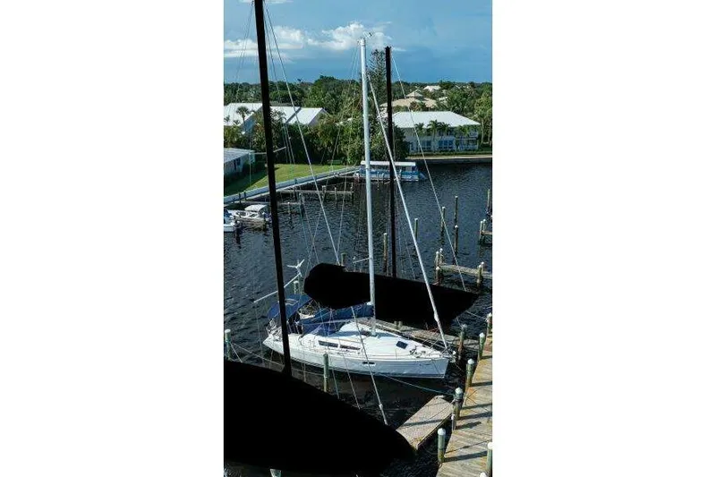 Slide: The Image of 2010 Jeanneau Sun Odyssey 36i sailboat docked at a marina, surrounded by calm waters. - 80