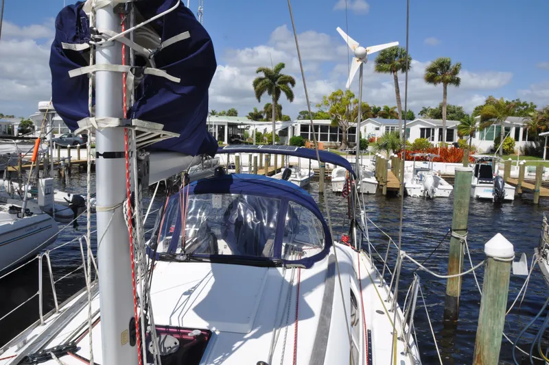 Slide: The Image of 2010 Jeanneau Sun Odyssey 36i sailboat docked at a marina with palm trees. - 9
