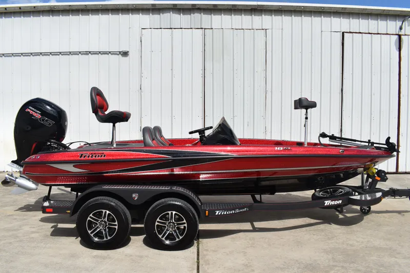 The Image of 2026 Triton 18 TrX bass boat in vibrant red on a trailer. - 0