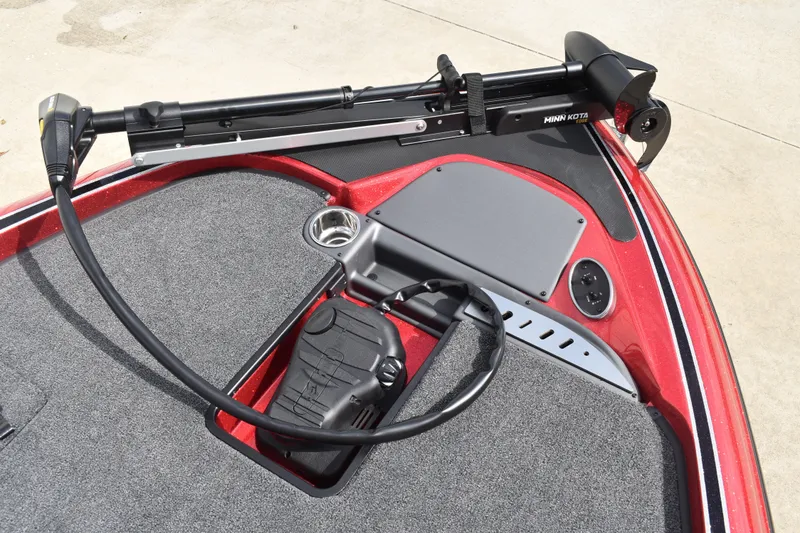 Slide: The Image of 2026 Triton 18 TrX boat deck with gray carpet and red trim. - 11