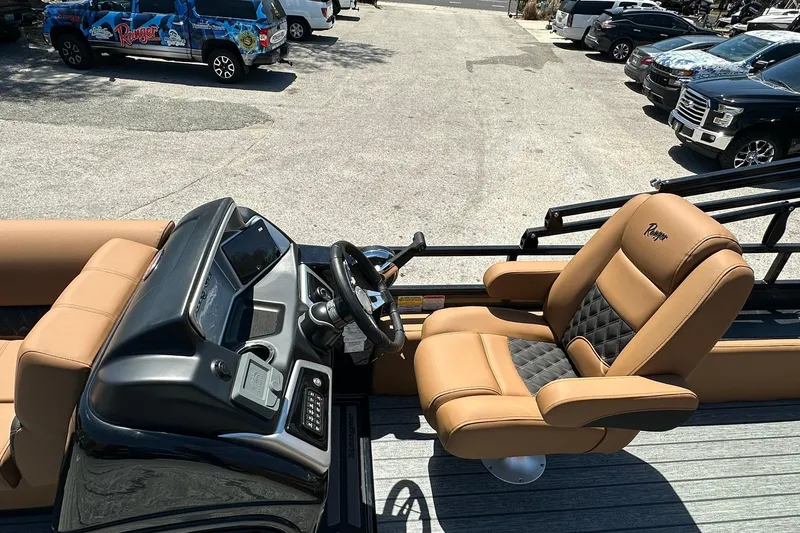 Slide: The Image of 2026 Ranger Reata 220FC boat interior with tan leather seats and steering console. - 17