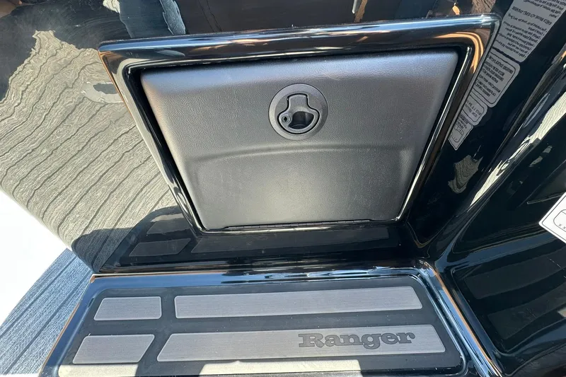 Slide: The Image of 2026 Ranger Reata 220FC boat compartment with sleek black finish and secure latch. - 24