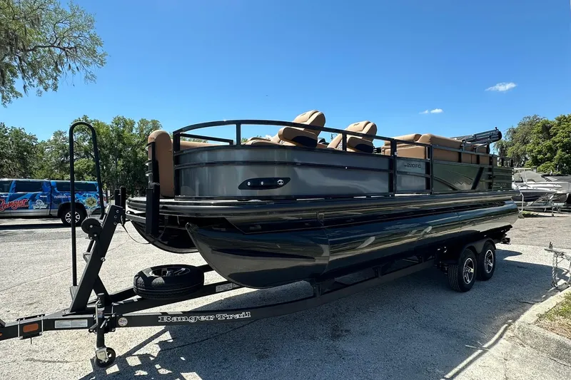 Slide: The Image of 2026 Ranger Reata 220FC pontoon boat on trailer, parked outdoors. - 3