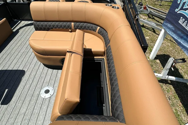Slide: The Image of 2026 Ranger Reata 220FC boat interior with tan and black seating, open storage compartment. - 30