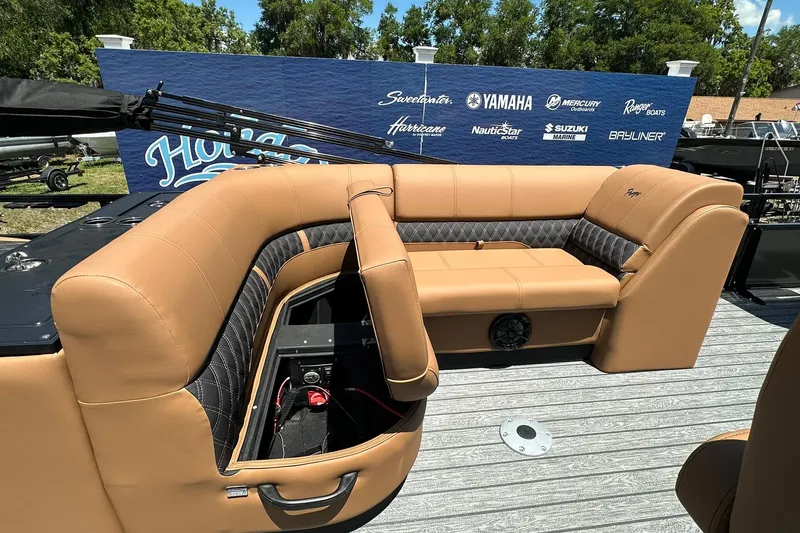 Slide: The Image of 2026 Ranger Reata 220FC boat interior with tan seating and branded backdrop. - 32