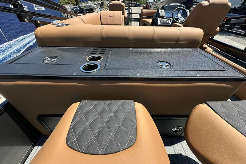 Slide: The Image of 2026 Ranger Reata 220FC boat interior with tan seating and black console. - 34