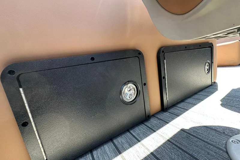 Slide: The Image of 2026 Ranger Reata 220FC storage compartments with black covers and metallic handles. - 35