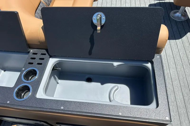 Slide: The Image of Open storage compartment on 2026 Ranger Reata 220FC boat with cup holders and seating. - 36