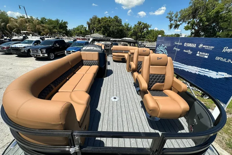 Slide: The Image of 2026 Ranger Reata 220FC boat with luxurious tan seating on display outdoors. - 6