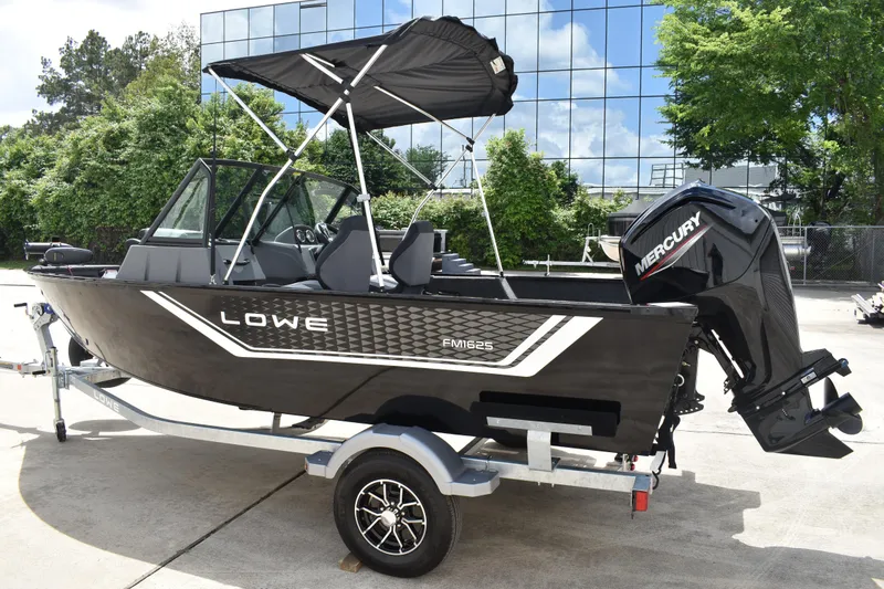 Slide: The Image of 2026 Lowe Fishing Machine 1625WT boat with Mercury engine on trailer, outdoors. - 7
