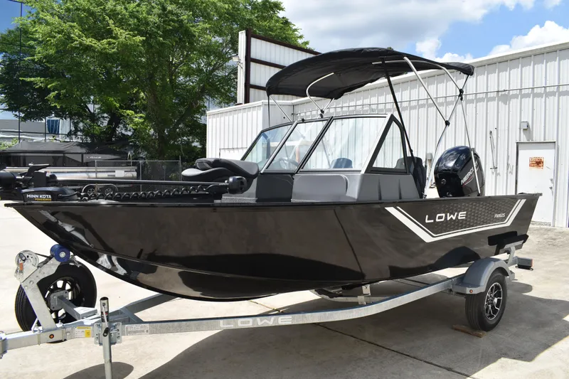 Slide: The Image of 2026 Lowe Fishing Machine 1625WT boat on trailer, black exterior, parked outdoors. - 8