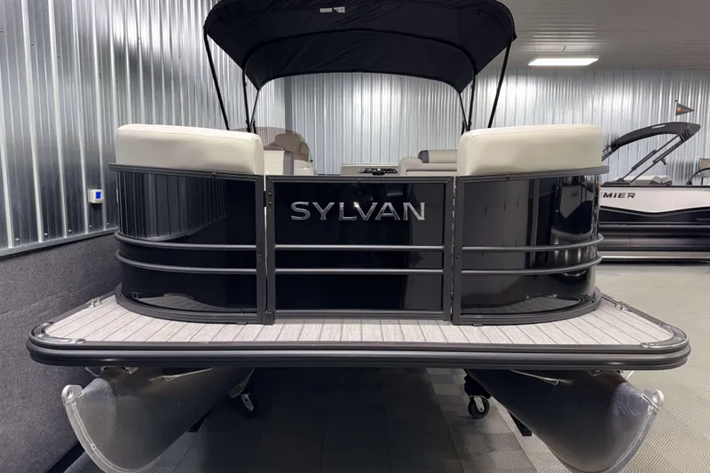 Slide: The Image of 2026 Sylvan Mirage 8520 Cruise pontoon boat in showroom, featuring sleek black design. - 19
