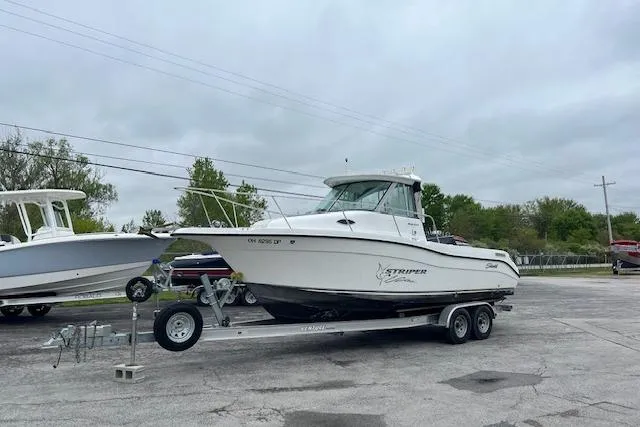 The Image of 2004 Seaswirl Striper 2601 Walkaround I/O boat on trailer in parking lot. - 0