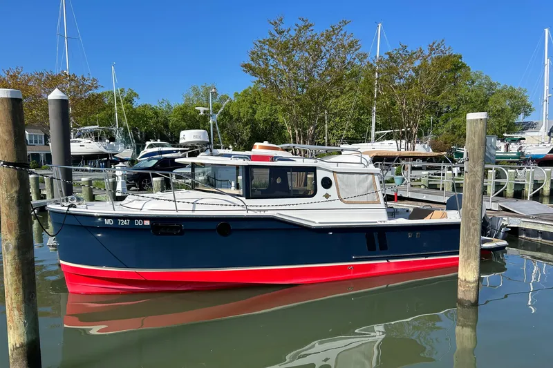 The Image of 2020 Ranger Tugs R-27 boat docked in a marina under clear blue skies. - 0