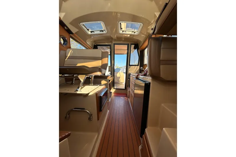 Slide: The Image of Interior view of 2020 Ranger Tugs R-27 boat, featuring seating and wooden flooring. - 10