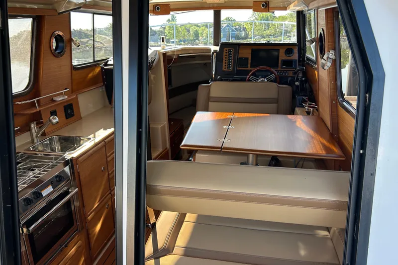 Slide: The Image of Interior of 2020 Ranger Tugs R-27 boat with kitchen and seating area. - 11