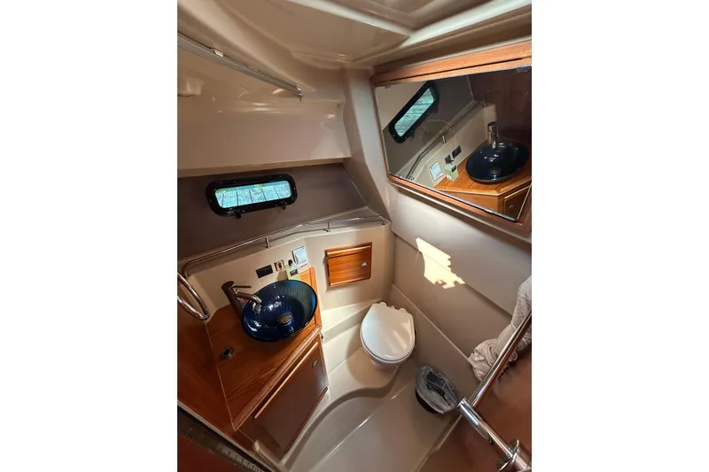 Slide: The Image of 2020 Ranger Tugs R-27 boat bathroom with sink, toilet, and mirror. - 16