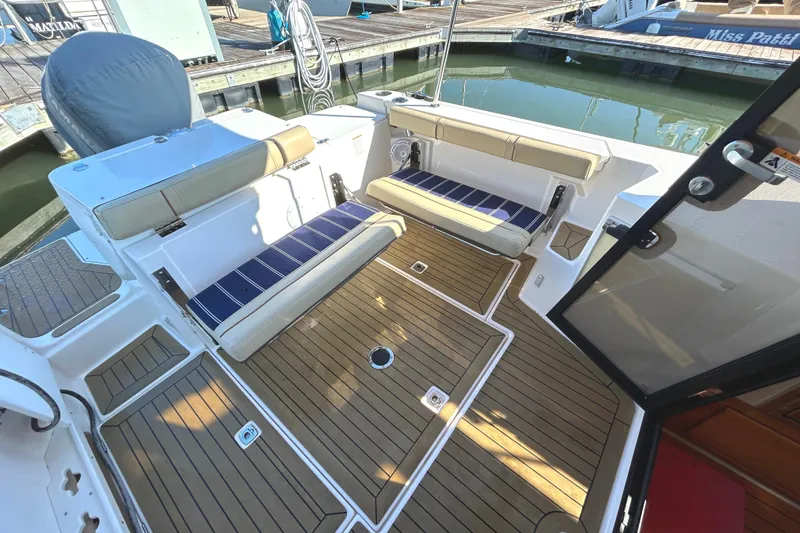 Slide: The Image of 2020 Ranger Tugs R-27 boat deck with cushioned seating and teak flooring. - 17