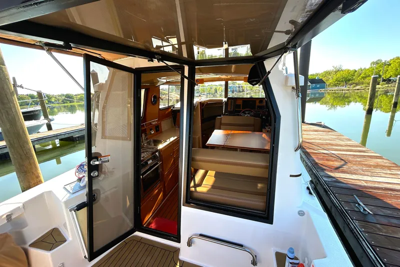 Slide: The Image of 2020 Ranger Tugs R-27 interior view with open door, dockside setting. - 18