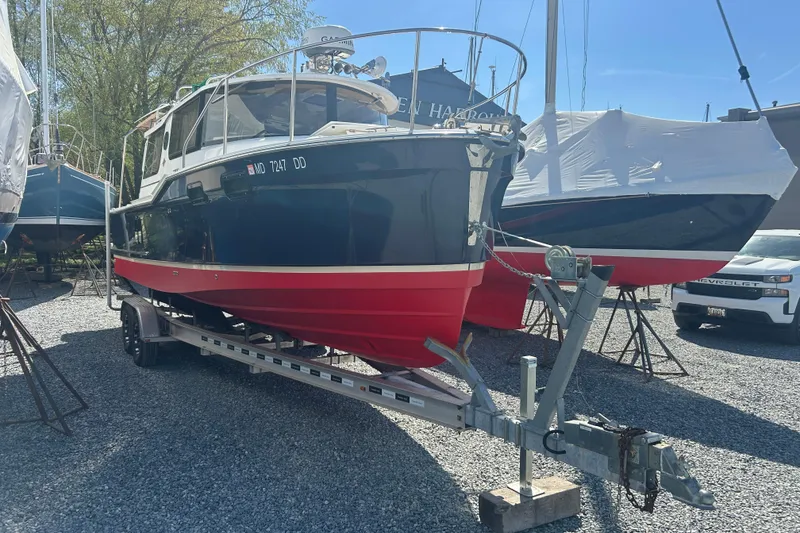 Slide: The Image of 2020 Ranger Tugs R-27 boat on trailer in a marina, sunny day. - 2
