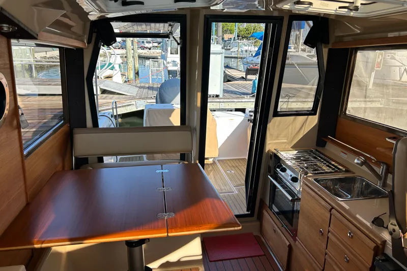 Slide: The Image of Interior of 2020 Ranger Tugs R-27 boat with dining table and kitchenette. - 8