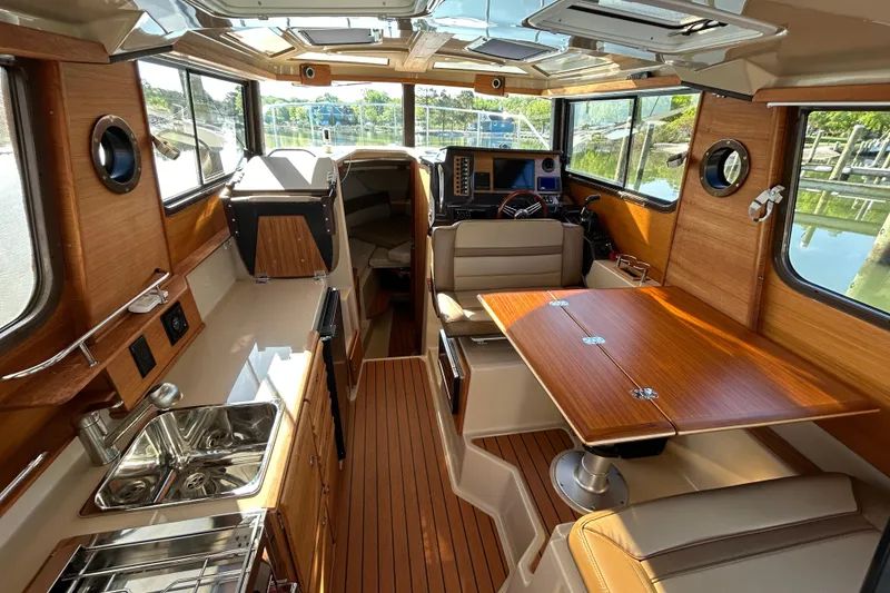 Slide: The Image of 2020 Ranger Tugs R-27 interior with wood finish, dining area, and helm station. - 9