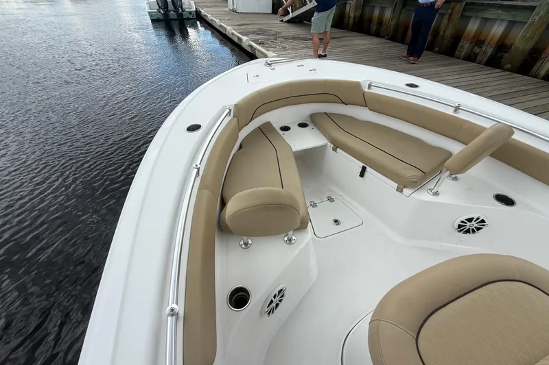 Slide: The Image of 2018 Sportsman Open 212 Center Console boat with tan seating, docked by the water. - 6