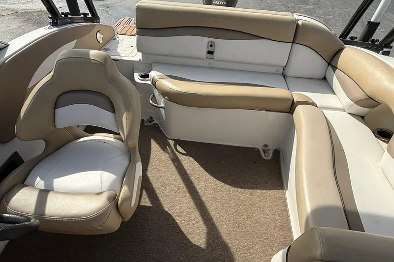 Slide: The Image of 2014 Starcraft Crossover 210 SCX OB boat interior with beige and white seating. - 13