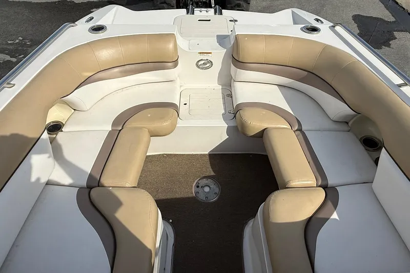 Slide: The Image of 2014 Starcraft Crossover 210 SCX OB boat interior with beige seating and carpeted floor. - 14